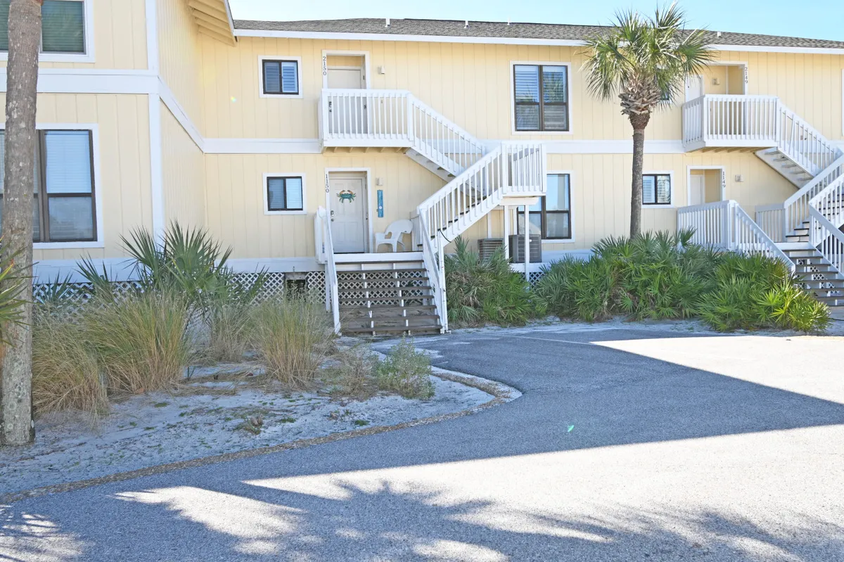 This exterior image captures a palm tree-lined walkway surrounded by lush greenery and connecting staircases leading to the units. The atmosphere is casual and inviting, with well-kept grounds, providing an ideal setting for dog walks and morning strolls.